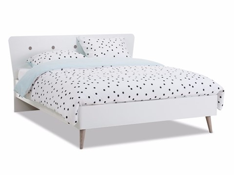 een wit bed met zwarte stippen erop