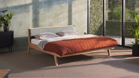 een bed met een rood dekbed en kussens