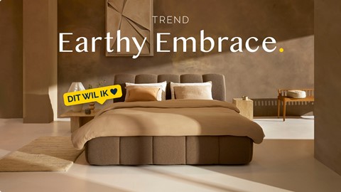 Een bed met een bruin bedframe