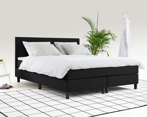 een bed met witte lakens en kussens