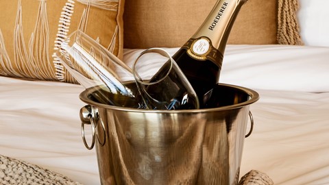 Champagne op bed in hotelkamer