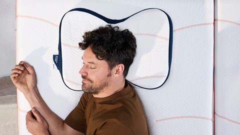 Een man die op een matras slaapt