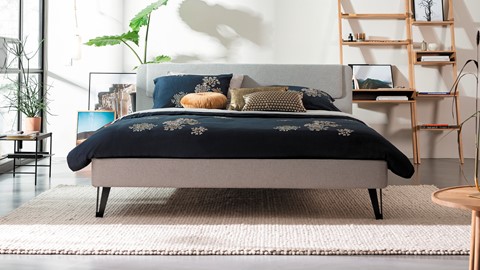 een bed met een zwarte deken en kussens