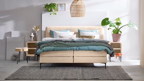een bed met een bedframe en een lamp
