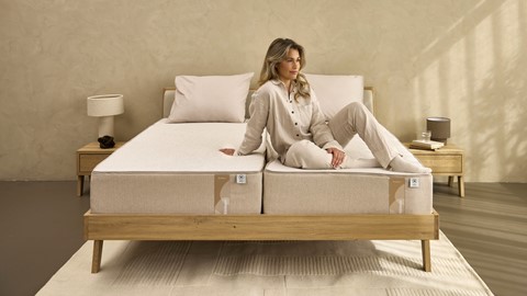 Een vrouw die op een bed zit