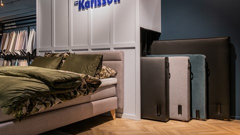 een bed met kussens en een doos in een kamer