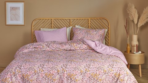 een bed met roze en witte lakens