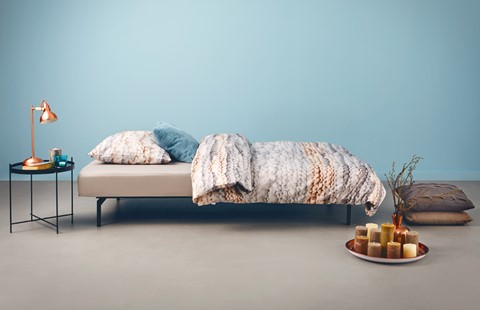 een bed met kussens en een bord met kaarsen