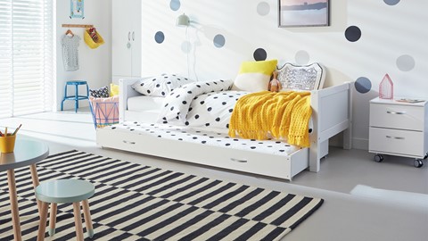 een wit bed met zwarte stippen erop