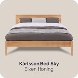 Een bed met een houten hoofdeinde