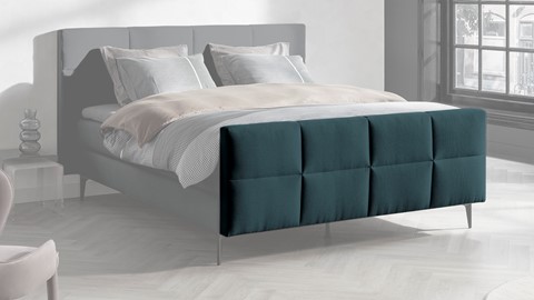 een bed met een blauw hoofdeinde
