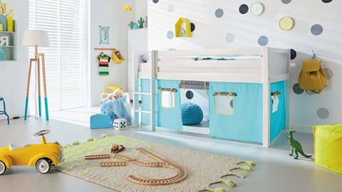 een wit-blauwe kamer met een bed en een treinspoor