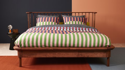 Een bed met kleurrijke kussens