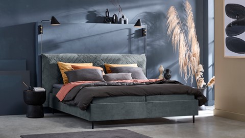 een bed met kussens en een lamp