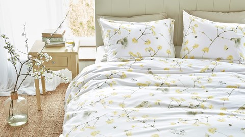 een bed met een bloemendekbed en kussens