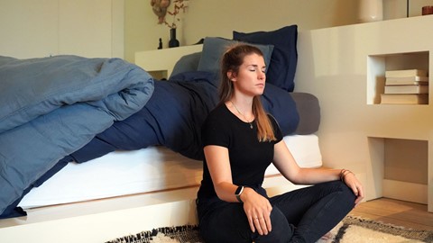 Vrouw is aan het mediteren op bed