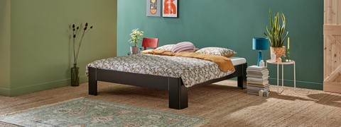 een bed met een plant aan de zijkant