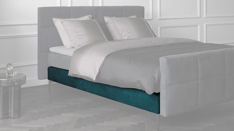 een bed met een blauw kussen
