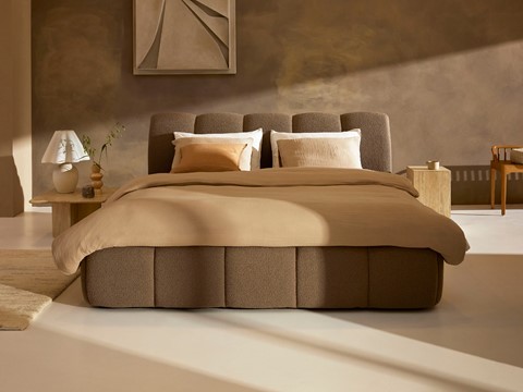 Een bed met een bedframe en een lamp