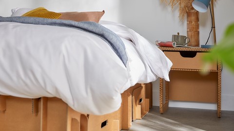 een bed met een witte deken en een witte deken erop