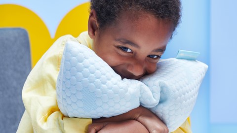 Een kind dat een kussen vasthoudt
