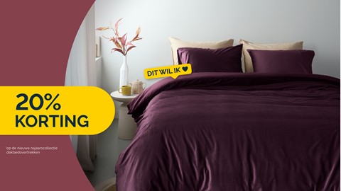 een bed met paarse lakens en een vaas met bloemen