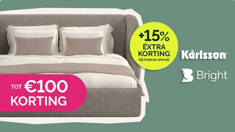 een bed met kussens en een bord