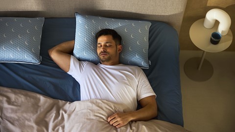 een man die in een bed slaapt