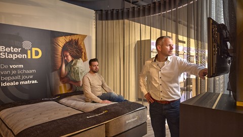 Een man die zich op een bed bevindt