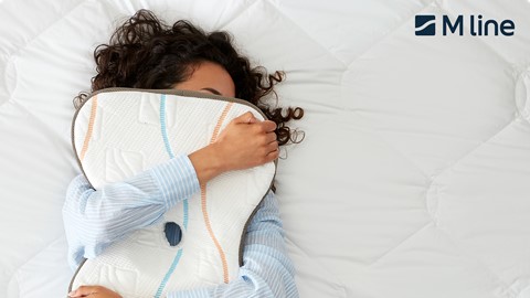 Een vrouw die op een bed ligt met een kussen