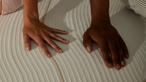 Iemands handen op een matras