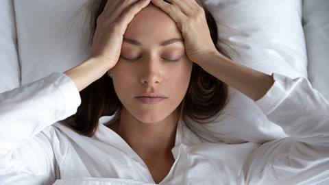 Vrouw ligt met stress in bed