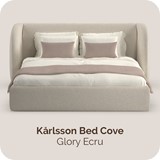 Een bed met kussens en een witte deken