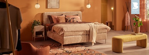 een bed met kussens en een tapijt in een kamer