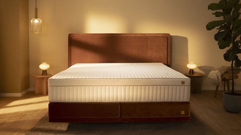 een bed met een hoofdeinde en een lamp