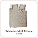 Een bed met een witte deken en kussens