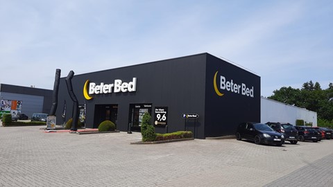 Een zwart gebouw met witte tekst en gele letters