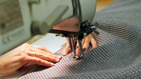 een persoon die een stuk stof naait