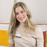 Een vrouw die bij camera glimlacht