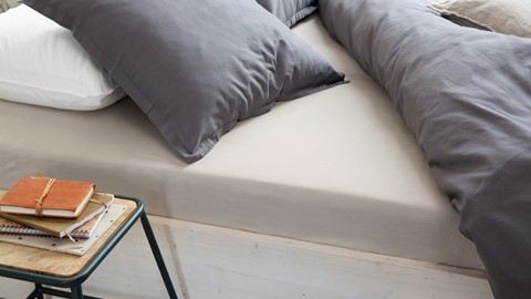 een bed met kussens en een tafel