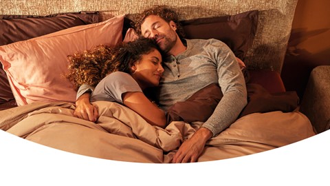 Man en vrouw liggen vrolijk in bed